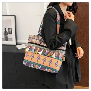 Detalle de bolso bandolera tejido estilo étnico con borlas coloridas y patrones geométricos.