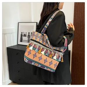 Vista detallada de un bolso tote étnico colorido con borlas bohemias llevado al hombro