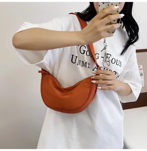 Bolso de nylon naranja con forma de media luna para mujer, usado como bandolera