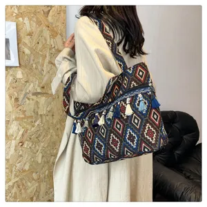 Bolso bandolera de estilo étnico tejido con patrones geométricos y borlas decorativas