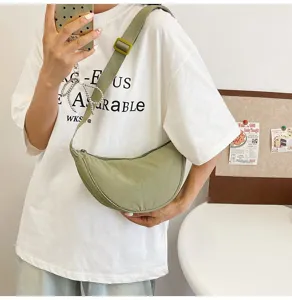 Bolso bandolera de nailon verde claro a la moda con forma de media luna en una modelo