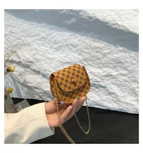 Detalle de un bolso bandolera vintage marrón con cadena dorada y estampado logo.