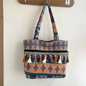 Bolso tote de lona de estilo étnico con borlas y motivos tribales geométricos.