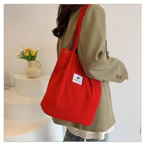Detalle de un elegante bolso de pana rojo llevado por una modelo en un estudio profesional