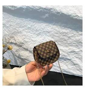 Primer plano de un mini bolso bandolera vintage marrón con cadena dorada elegante