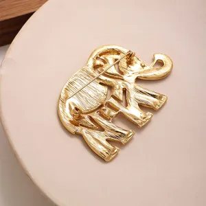 Vue détaillée de la broche éléphant dorée montrant le fermoir à épingle au dos.