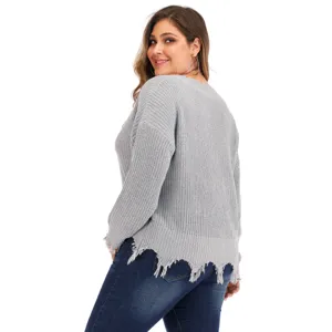 Plus size grey knit sweater featuring chic V-neck and frayed tassel hem detail view.