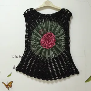 Handmade crochet black sleeveless women top with pink floral appliqué and green fringe trim.