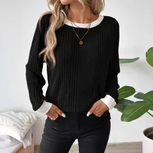 Detailaufnahme des schwarzen Rippstrick-Pullovers mit schickem weißem Kontrast-Rundhalsausschnitt.