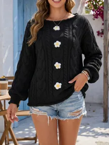 Jersey de punto negro con elegante cuello barco y bonitas aplicaciones de margaritas para otoño.