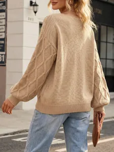 Outdoor street view detail showing the back and lantern sleeves of a cozy beige knit sweater.