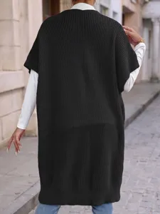 Vista detallada de un chaleco de punto negro informal combinado con camiseta blanca de manga larga.