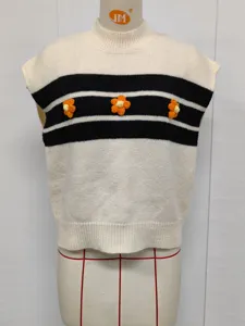 Détail en gros plan du gilet en tricot pour femmes avec rayures noires et fleurs au crochet.