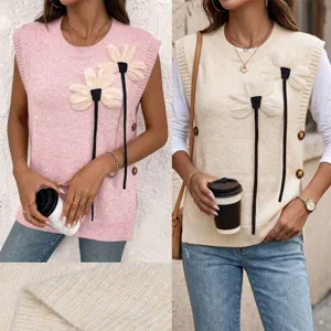 Close-up of knit vest featuring 3D flower appliqués and decorative side buttons.