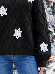 Schwarzer Strickpullover mit handgehäkelten weißen Schneeflocken und Rautenmuster Detail.