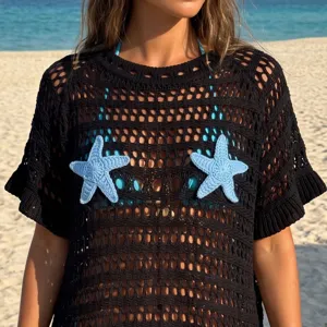 Detailed view of black crochet beach cover-up featuring light blue starfish appliques