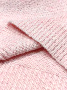 Nahaufnahme des weichen rosa Strickstoffs mit detailliertem Maschenbild und Textur
