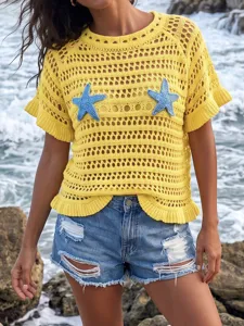 Detailed view of yellow hollow-out crochet beach cover-up with blue starfish motifs