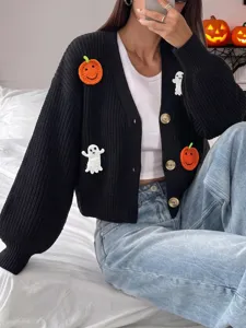 Primo piano del cardigan nero in maglia con simpatiche patch fatte a mano di zucche e fantasmi.