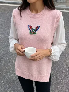 Detailansicht einer rosa Strickweste mit buntem Pailletten-Schmetterlings-Patch.