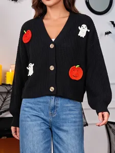 Primo piano del cardigan in maglia nera con toppe all'uncinetto a tema zucca e fantasma per Halloween.