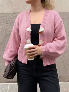 Nahaufnahme der kuscheligen rosa Strickjacke mit Hornknöpfen für modische Herbst-Outfits.