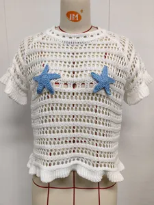 Detail of blue crochet starfish applique on white hollow-out knit beach cover-up