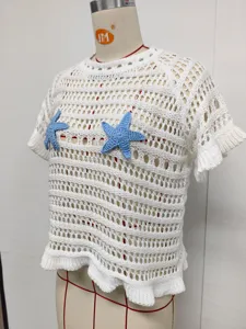 Detailed view of white crochet knit beach cover-up with blue starfish appliques