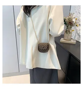 Elegante mini bolso bandolera vintage marrón con cadena dorada usado por una modelo