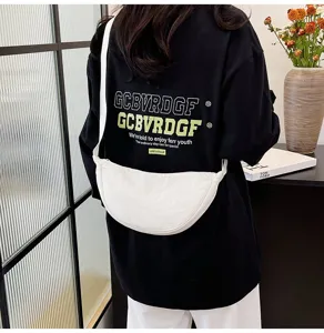 Detalle del bolso dumpling de nylon blanco visto desde atrás en una persona de negro