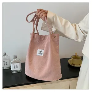 Detalle de un bolso de hombro de pana rosa en un entorno de estilo de vida minimalista y acogedor