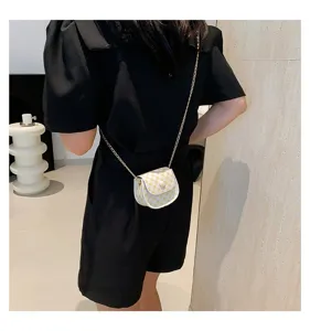 Vista posterior de una mujer con un mini bolso bandolera a cuadros y cadena de oro