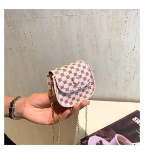 Primer plano de un mini bolso rosa con patrón geométrico retro y correa de cadena.