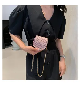 Vista detallada de un mini bolso bandolera rosa vintage con cadena y diseño de monograma