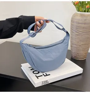 Primer plano detallado de un elegante bolso bandolera de nailon azul claro en forma