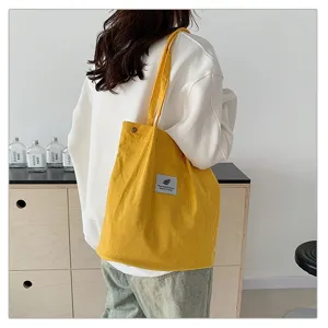 Vista detallada de un bolso shopper de pana amarilla que muestra textura y estilo