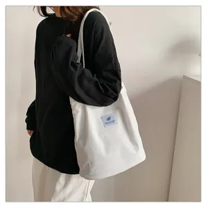 Vista detallada de un bolso shopper de pana blanca para mujer con textura suave