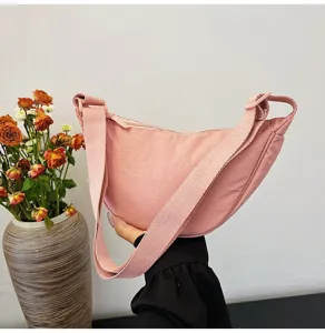 Primer plano de un bolso medialuna de nailon rosa que muestra su forma y textura