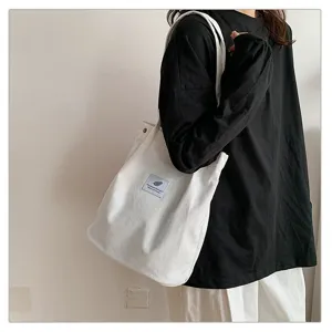 Detalle de un bolso de pana blanco de estilo minimalista llevado como bolso de hombro