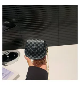Vista detallada de un mini bolso de cadena vintage de mano con un patrón elegante y chic