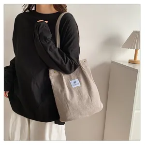 Modelo con un bolso de hombro de pana beige minimalista con gran capacidad de carga