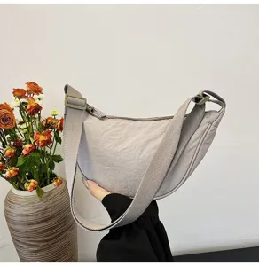 Vista detallada de un bolso de nailon minimalista que muestra su forma de medialuna.