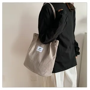 Vista detallada de la textura de pana y el diseño minimalista de este bolso tote beige