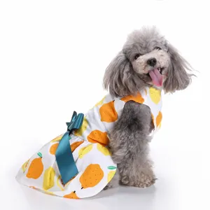 Detail view of a white pet summer dress with orange fruit prints and green bow