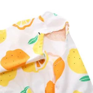 Detailed close-up of pet summer dress with vibrant lemon pattern and stitching