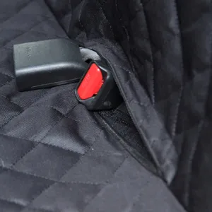 Pet car seat cover detail showing the seatbelt buckle slot and waterproof quilted black fabric.