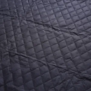Close-up detail of dark quilted pet car seat cover fabric, showing neat diamond stitching.