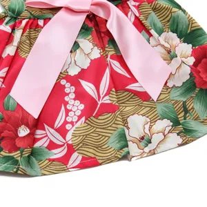 Detailed macro view of a floral print pet summer dress with a vibrant pink bow accent