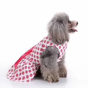 Side view of a grey poodle wearing a cute white floral pet dress with a red bow