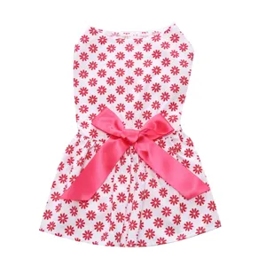 Close-up of a white pet summer dress with red floral print and a large pink satin bow.